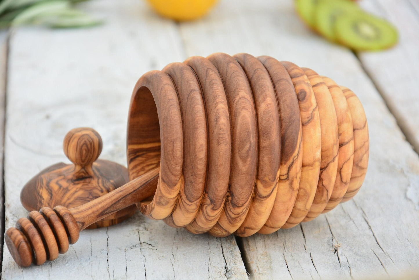 Handgefertigter Honigtopf aus Olivenholz in Bienenkorb-Design auf rustikalem Holztisch