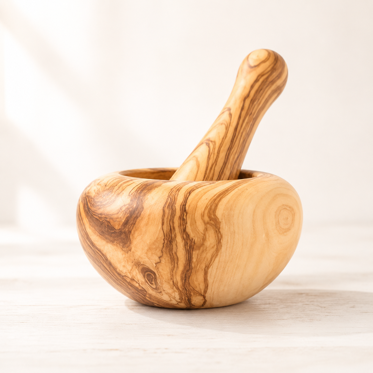 Handgefertigter Olivenholz Mörser mit Stössel für Gewürze, Kräuter und Pesto in der Schweizer Küche.