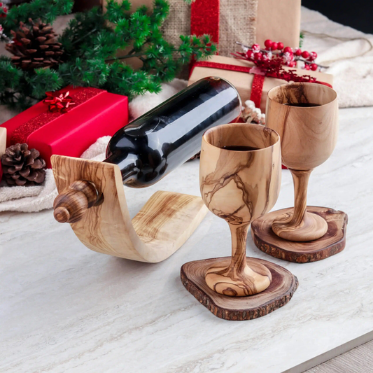 Geschenkset mit zwei handgefertigten Holzkelchen aus tunesischem Olivenholz, inklusive Flaschenhalter und Verschluss, auf mediterranem Hintergrund