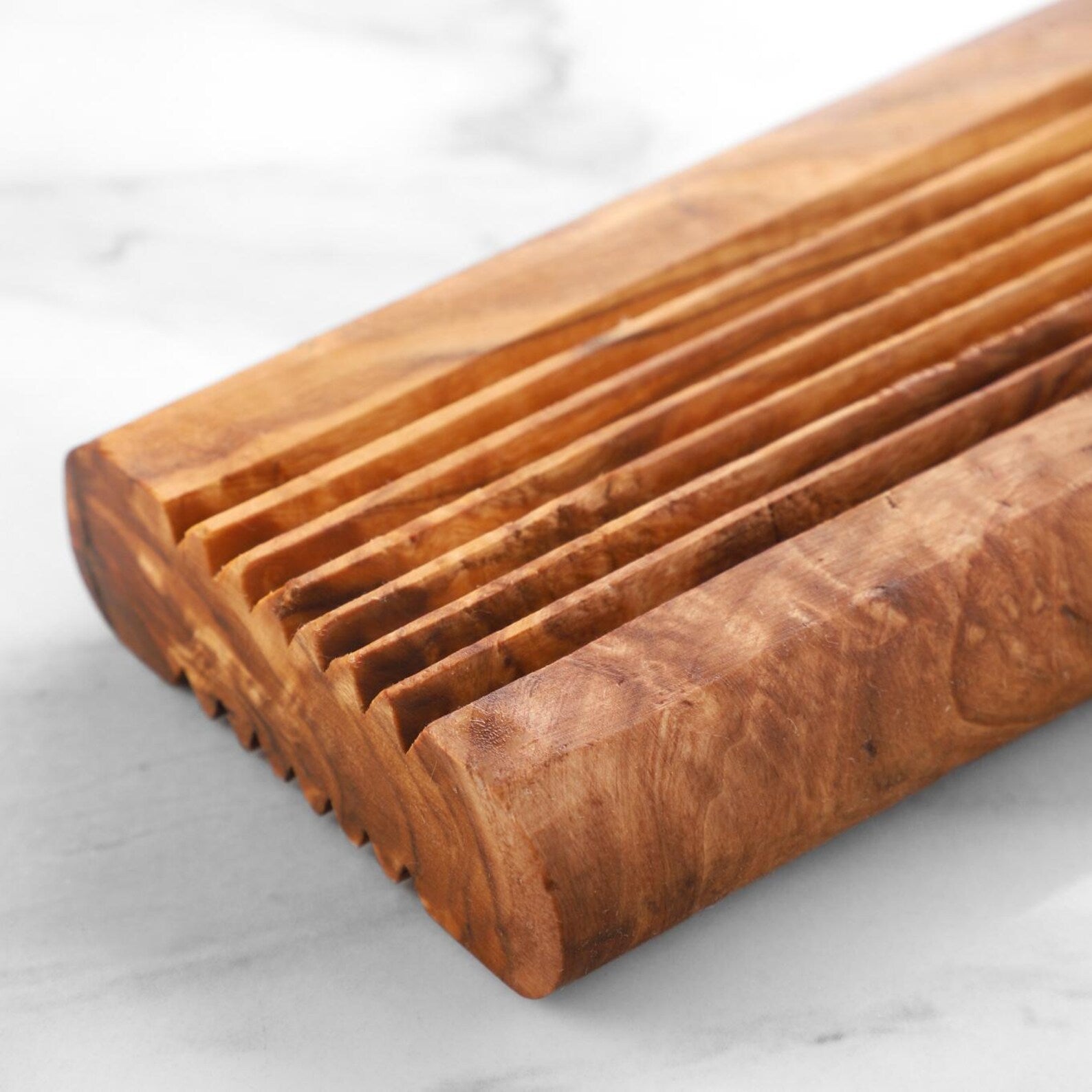 Seifenschale aus mediterranem Olivenholz, detailreiche Nahaufnahme der warmen Holzstruktur.